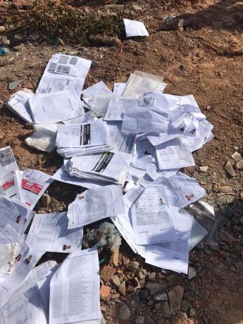 Documentos jogados em terreno baldio